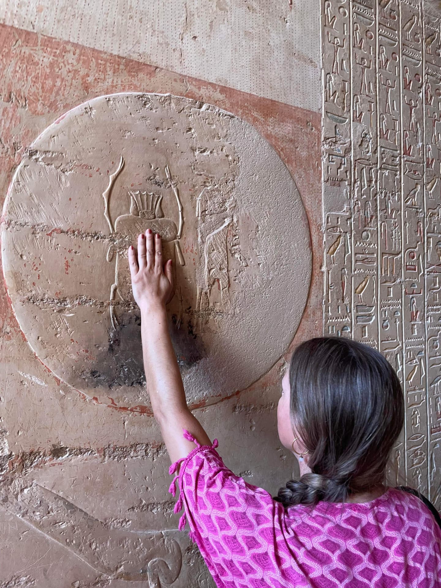 Sunniva Aatangen med hånden på et skarabé-relieff i et egyptisk tempel